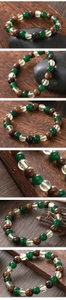 Macro detail of natural tiger eye and green agate beaded stretch bracelet on dark wood