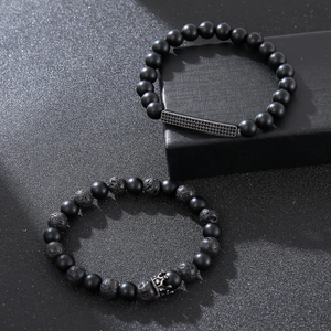 Matte black obsidian and volcanic stone stretch bracelet set with a black crown charm