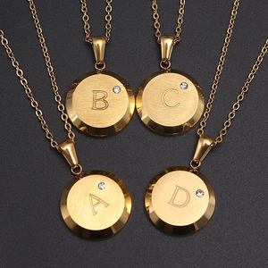 Collares dorados con colgantes redondos letras A-D, acabado cepillado y circón sobre negro