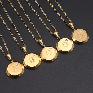 Collares de letras A-E de acero inoxidable dorado con circón sobre fondo negro de lujo