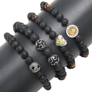 Lava stone bead bracelet set with Saint Benedict medal and heart charm on display
