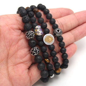 Three-piece black volcanic stone and tiger eye bead bracelet set with gold saint charms