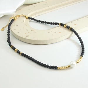 Minimalist necklace with black lava stone beads, white pearl, and gold stainless steel