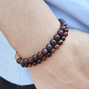 Double-layer red tiger eye stone beaded bracelet with gold spacers on wrist