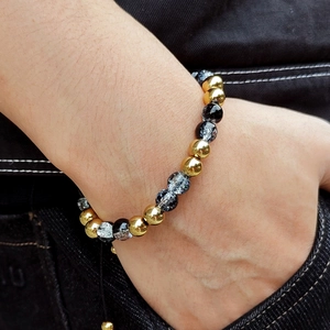 Adjustable stainless steel and natural stone beaded bracelet on a person's wrist