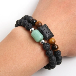 Set di bracciali da uomo in occhio di tigre e pietra lavica indossati su sfondo bianco