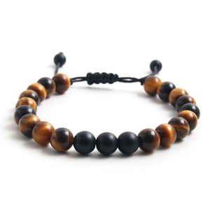 Detalle de pulsera ajustable de ojo de tigre y cuentas de piedra negra mate con cordón