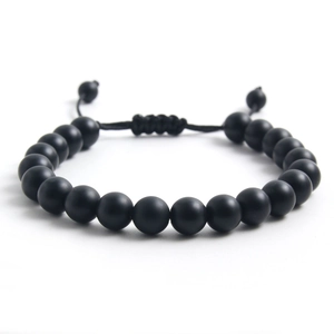 Detalle de la pulsera de cuentas de piedra negra mate con cordón tejido ajustable