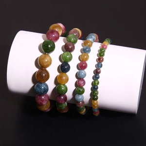 Bracelets en perles de pierre naturelle colorées présentés sur un support blanc