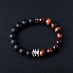 Close-up of matte black beads and tiger eye stone bracelet with silver spacers