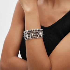 Detail of silver-plated layered beaded stretch bracelets worn on a female wrist