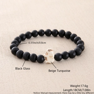 Detail of 8mm matte black glass beads and a beige turquoise elephant charm bracelet