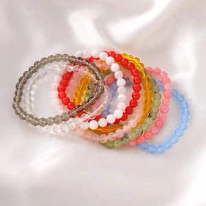 Macro detail of multi-colored 6mm glass beads on silk, showing smooth texture and luster