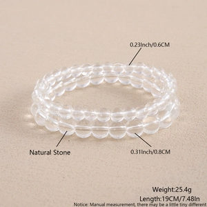 Detailed view of 6mm and 8mm clear natural stone beads on a textured background