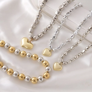 Punk style beaded necklace set with bold gold heart pendants on elegant silk background