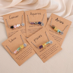 Detail view of zodiac necklaces with natural crushed stones and silver chain on cards