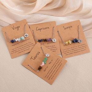 Detail of zodiac necklaces with natural crushed stones on kraft paper card packaging