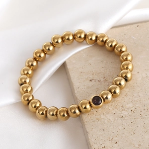 18K gold plated stretch bracelet with polished beads and purple zircon accent