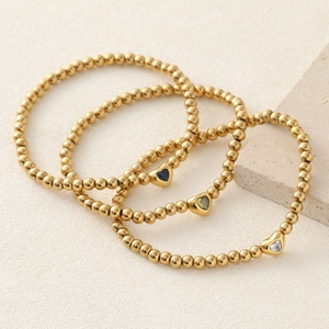 Three-piece gold beaded bracelet set featuring colorful heart-shaped zircon charms