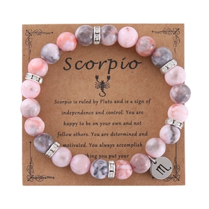 Detail of 8mm pink zebra jasper Scorpio zodiac bead bracelet on craft paper display card