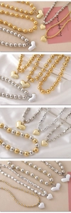 Detail of assorted heart pendant beaded necklaces in gold and silver finishes