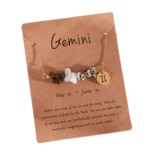 Gemini zodiac necklace with gold pendant and natural crushed stones on vintage card