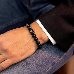 Primer plano de una pulsera para hombre de cuentas con ojo de tigre y dije dorado letra B