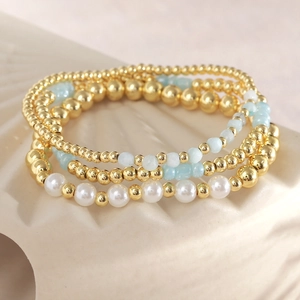 Set of four stretch bracelets with natural stone beads and pearls on ceramic base