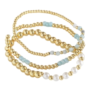 Stackable four-piece beaded bracelet set with gold metal beads, blue stones and white pearls