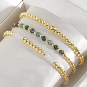Driedelige stapelbare kralenarmbandset met gouden kralen en natuurlijke groene stenen
