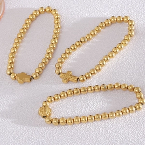 Ensemble de trois bracelets à perles dorées pour femmes avec divers pendentifs croix