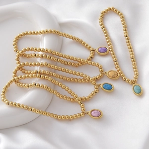 Gold beaded bracelets with colorful natural birthstone oval pendants on silk