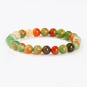 Détail de perles rondes en agate naturelle colorée avec rayures et textures sur fil élastique