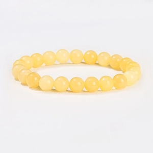 Détail macro de perles de cristal jaune translucide naturel sur un bracelet simple