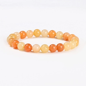Détail macro du bracelet en perles de pierre naturelle avec billes polies orange et crème