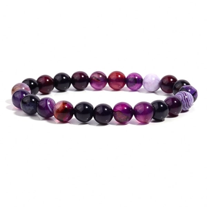 Gros plan de perles d'agate naturelle rayées aux tons violets et bordeaux sur bracelet