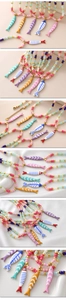 Detail of multi-color enamel fish pendants and S.STEEL engraved extender on beaded necklace