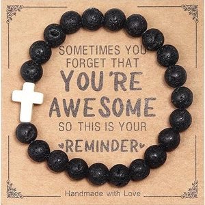 Handmade lava rock beaded bracelet with white cross charm on vintage display card