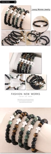 Close-up of beaded bracelets with tiger eye, lava stones and silver cross charm detail