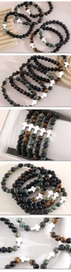 Close-up of five beaded bracelets featuring tiger eye stones and silver crosses