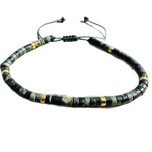 Adjustable ethnic bracelet with green natural stone beads and gold metal spacers on cord