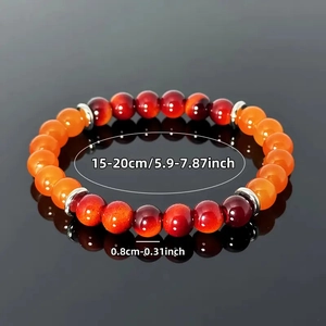 Elastic beaded bracelet with red tiger eye stones and silver spacers on black surface