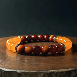 Tiger eye and topaz style beaded stretch bracelet with silver spacers on wooden base