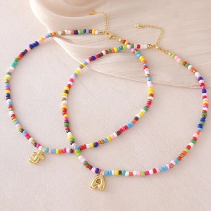 Collana di perline colorate con ciondoli a lettera J e A placcati in oro