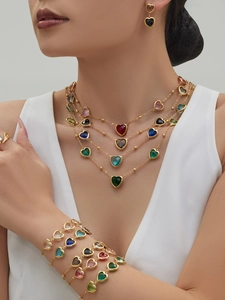 Detail von mehrlagigen Herz-Halsketten und Armbändern mit bunten Edelstein-Akzenten