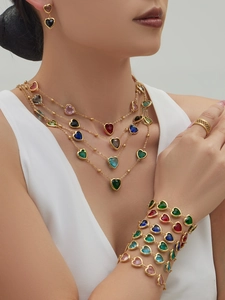 Detailansicht von geschichteten bunten Herz-Edelsteinketten und Armbändern an einem Model