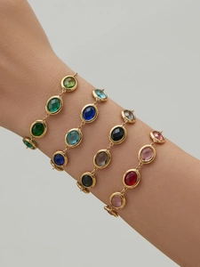 Close-up of 18k gold plated bracelets with faceted colorful gemstones on a model wrist