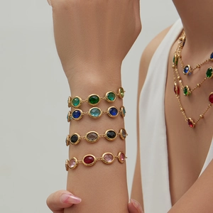 Colorful faceted glass stone bracelets in 18k gold plated stainless steel on a wrist