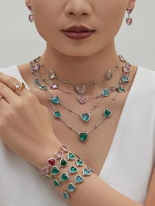 Nahaufnahme eines Models mit mehrlagigem Schmuckset aus bunten, herzförmigen Glassteinen