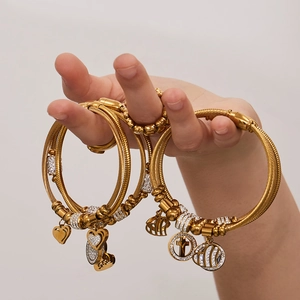 Golden cable bracelet with heart and cross charms and shimmering cubic zirconia stones